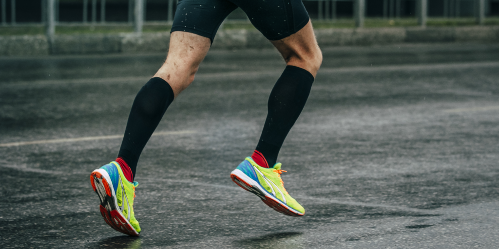 A person running while wearing athletic compression socks.